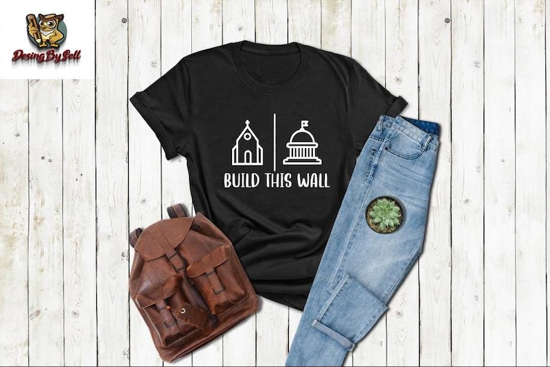 a t - shirt that says build this wall next to a pair of jeans