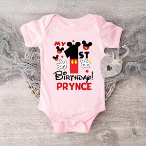 a pink bodysuit with mickey mouse on it