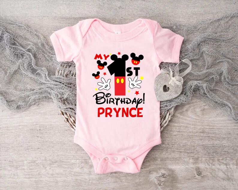 a pink bodysuit with mickey mouse on it