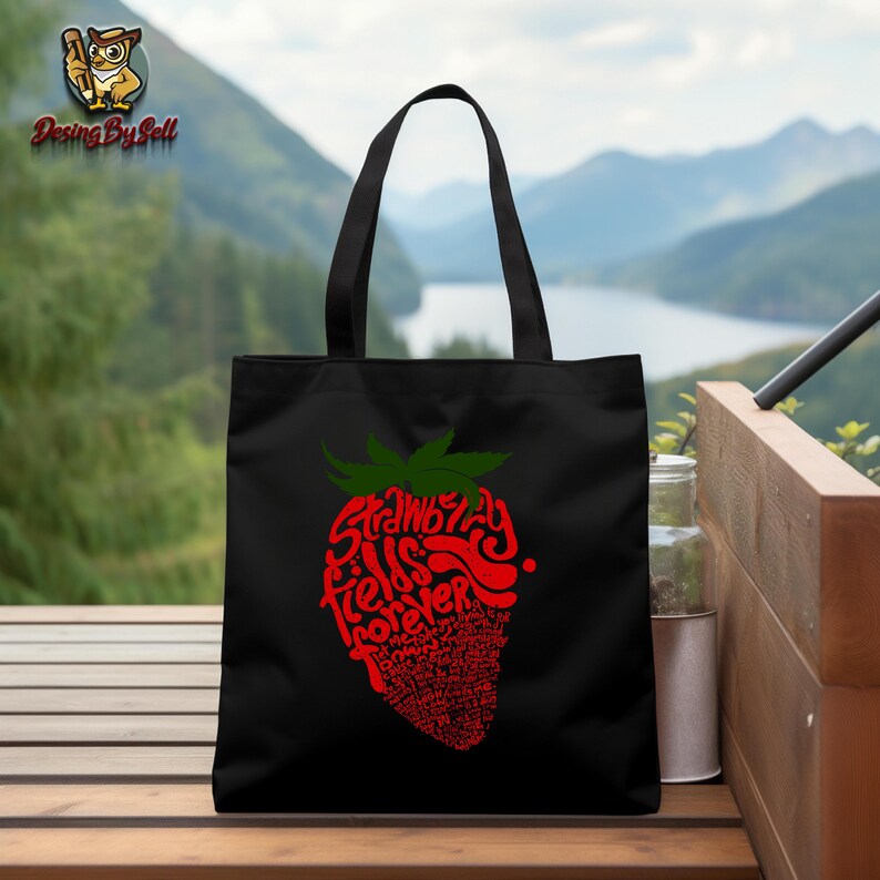 May include: Black tote bag with a red and green strawberry graphic. The strawberry is made up of the words "Strawberry Fields Forever".