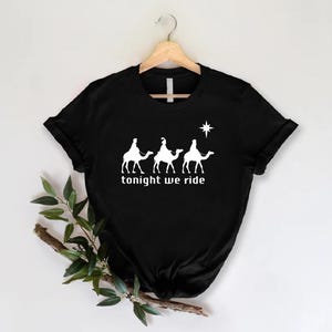 a black t - shirt with the words tonight we ride on it