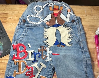Kids Cowboy Custom Painted Birthday Denim Overalls for Little Boys Featuring Western rodeo design, lasso, name and age in patriotic colors