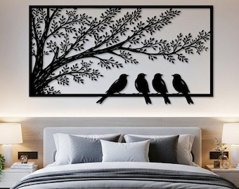 May include: A rectangular black metal wall art piece featuring a silhouette of a tree with spreading branches and four birds perched on a horizontal line. The design is enclosed within a thin black frame, creating a stark contrast against the wall.