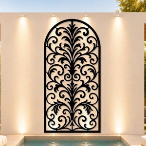 May include: A black metal wall art piece with an arched top, featuring a symmetrical, ornate floral design. The artwork is mounted on a white wall, above a swimming pool. The scene is outdoors, with a modern aesthetic.