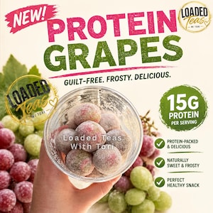 以下が含まれることがあります： ピンク色の「NEW！」の文字が入った「Protein Grapes」の広告。画像には、テキスト「Loaded Teas With Tori」が入った、霜で覆われたブドウが入った透明な容器が写っています。広告は「15G Protein Per Serving」を強調し、スナックを「Protein-Packed & Delicious」としています。
