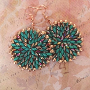 May include: A pair of round, turquoise and copper earrings with a beaded design. The earrings are made with small, iridescent beads and have a delicate, feminine look.