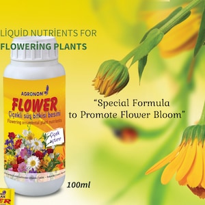 Könnte beinhalten: Eine 100 ml Flasche flüssiger Pflanzennährstoffe namens "Agronom Flower" für blühende Zierpflanzen. Die Flasche ist grün und weiß mit einem Bild von Blumen auf der Vorderseite. Der Text auf der Flasche lautet "Spezialformel zur Förderung der Blütenbildung".