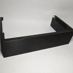 May include: Black plastic case with a rectangular shape and a small vent on the top right corner.