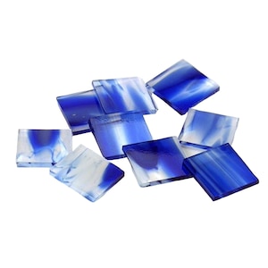 May include: A collection of blue and white glass mosaic tiles. The tiles are square and have a swirling pattern.