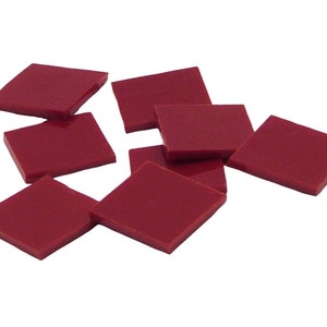 May include: Eight burgundy red square tiles, scattered on a white background.