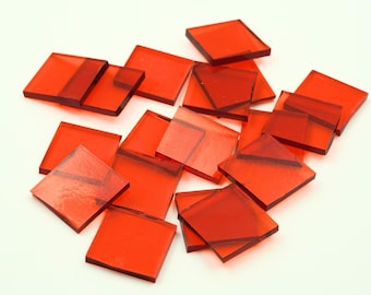 May include: A pile of red glass tiles, perfect for crafting projects. The tiles are square and have a translucent, slightly iridescent finish.