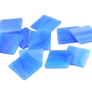 May include: A collection of ten light blue glass tiles with a white marbled pattern. The tiles are square shaped and have a smooth, glossy finish.