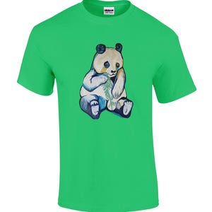 May include: A vibrant green t-shirt with a watercolour illustration of a panda bear. The panda is in white, blue, and black, sitting and holding bamboo. The shirt has a crew neck and short sleeves.