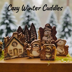 Könnte beinhalten: Eine Sammlung von Winterfiguren, darunter ein Haus, Bäume, ein Pinguin, ein Schneemann, eine Maus und ein Eisbär. Die Figuren sind in warmen Tönen bemalt und vor einem verschwommenen Hintergrund aus verschneiten Bäumen platziert. Der Text "Cozy Winter Cuddles" steht oben.