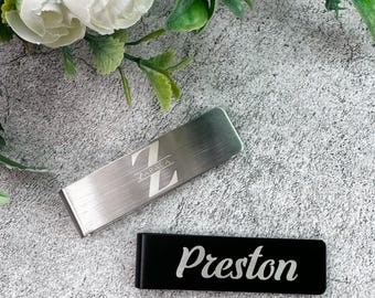 May include: Two silver money clips. One has the name "Zabala" and the letter "Z" engraved on it. The other has the name "Preston" engraved on it.