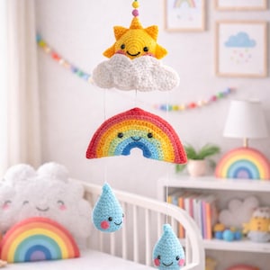 May include: A handmade crochet baby mobile featuring a smiling yellow sun, a white cloud, a rainbow, and two blue raindrops. The mobile is suspended from a wooden ring and is designed for a nursery.