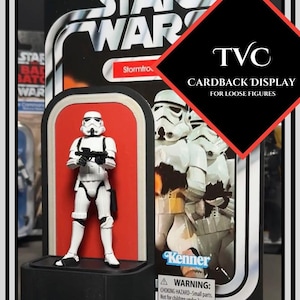 May include: A white Star Wars Stormtrooper action figure displayed on a black and red cardback. The cardback features the Star Wars logo, the Kenner logo, and the text "TVC Cardback Display for Loose Figures".