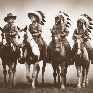 Könnte beinhalten: Vier Kinder in traditionellen indianischen Kopfbedeckungen reiten auf Pferden. Die Kinder tragen alle Cowboyhüte und lächeln. Die Pferde sind alle braun und weiß.