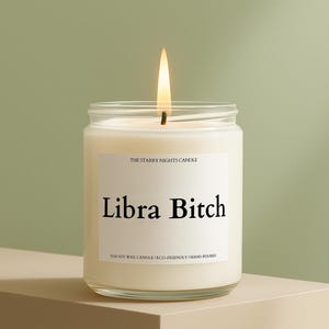 May include: A lit, white soy wax candle in a glass jar. The label reads "Libra Bitch" in bold black letters. The text "THE STARRY NIGHTS CANDLE" and "%100 SOY WAX CANDLE | ECO-FRIENDLY | HAND-POURED" are also visible.