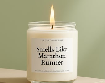 May include: A lit, white soy wax candle in a clear glass jar. The label reads "Smells Like Marathon Runner." The candle is hand-poured and eco-friendly. The flame is bright against a neutral background.