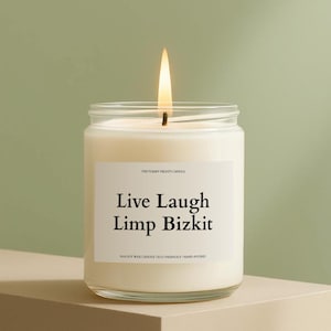 May include: A lit soy wax candle in a clear glass jar. The candle has a white label with the text "Live Laugh Limp Bizkit". The candle is hand-poured and eco-friendly.