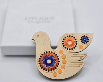 Broche de madera contrachapada de abedul con diseño de pájaro escandinavo/folclórico, pintado y bordado a mano.