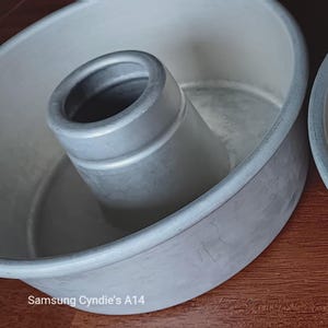 May include: Two silver metal cake pans with a removable center tube. The pans are designed for making bundt cakes.