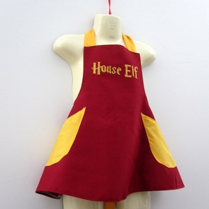 May include: Red and yellow apron with the text "House Elf" embroidered on the front.