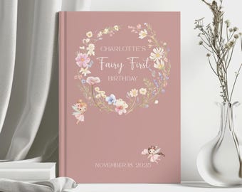 May include: A dusty rose-colored book with the text "Charlotte's Fairy First Birthday" surrounded by a floral wreath. Two small fairy illustrations are on the cover, along with the date November 18, 2025.