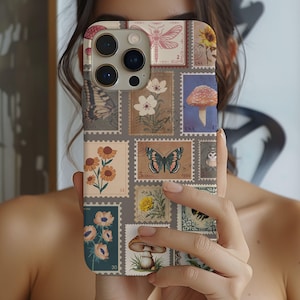 May include: A phone case with a vintage aesthetic featuring a collage of butterflies, flowers, mushrooms, and other nature-inspired imagery. The case has a light grey background with a subtle texture.