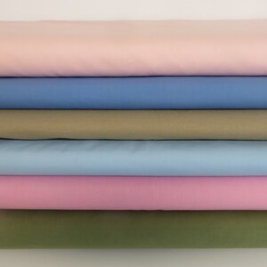 May include: Stack of six fabric swatches in various colors, including pink, blue, and green.