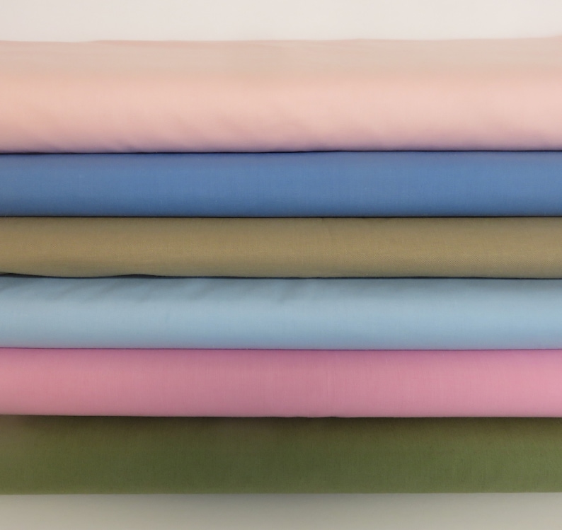 May include: Stack of six fabric swatches in various colors, including pink, blue, and green.