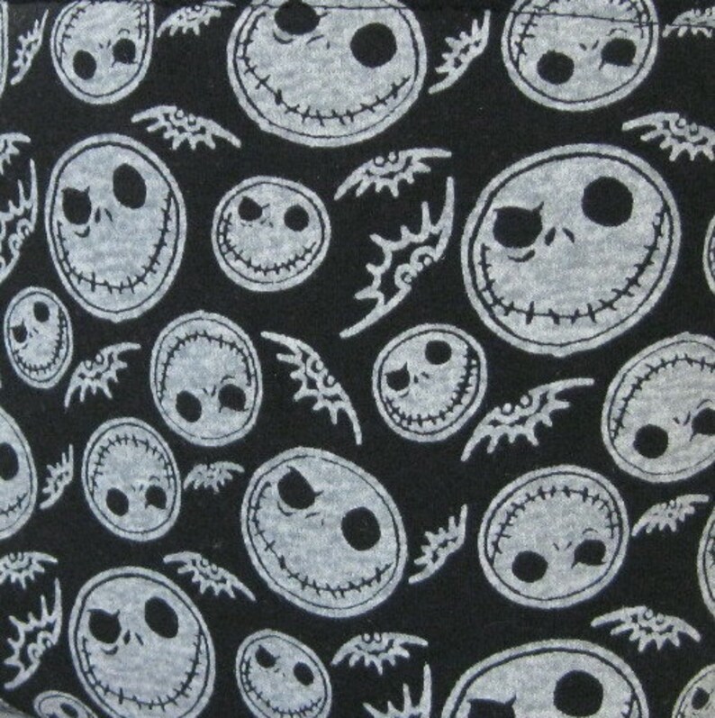 Puede incluir: Tela negra con un patr&oacute;n repetido de caras blancas de Jack Skellington de Pesadilla antes de Navidad. El dise&ntilde;o incluye caras de varios tama&ntilde;os y formas de murci&eacute;lago.