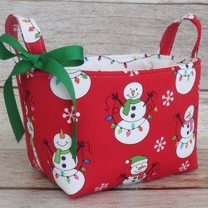 Sneeuwpop en kerstverlichting op rood, vakantie kerststof, opbergorganisatie container bak organisator mand