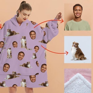 May include: A purple hooded blanket with a repeating pattern of a person's face and a dog. The blanket has a large pocket in the front and is made of soft fleece.