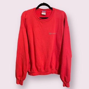 May include: Red Champion sweatshirt with a small white logo on the front.