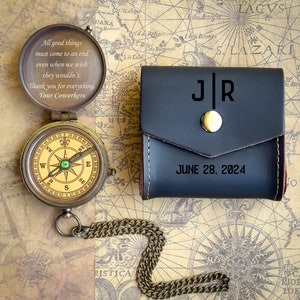 May include: A brass compass with a green jewel in the center, a black leather case with the initials "J|R" and the date "JUNE 28, 2024" engraved on it, and a gold chain.