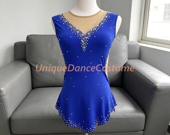 May include: A sleeveless royal blue leotard featuring a nude-colored mesh neckline insert and a V-shaped bodice adorned with scattered clear crystals. The garment has a scalloped hemline embellished with crystals and the text UniqueDanceCostume.