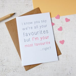 White background, with craft envelope and white A6 greeting card reading i know you say we are all your favourites but im your most favourite...right? Writing is in grey except for im your most favourite which is in a rose pink