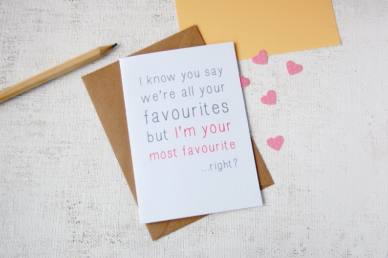White background, with craft envelope and white A6 greeting card reading i know you say we are all your favourites but im your most favourite...right? Writing is in grey except for im your most favourite which is in a rose pink