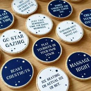 Twenty four wooden tokens, each with a recycled label that have a date night idea printed on, lay on a wooden desk.