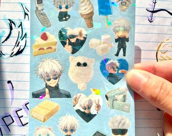 May include: A sticker sheet with various holographic images of Satoru Gojo from Jujutsu Kaisen. The sheet includes images of Gojo, desserts, and a flip phone. The text "Satoru Gojo <3" is at the top of the sheet.