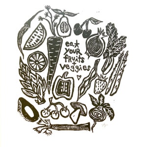 May include: Black and white linocut print of various fruits and vegetables, including a carrot, watermelon, onion, cherries, asparagus, and a mushroom. The text "eat your fruits + veggies" is included in the print.