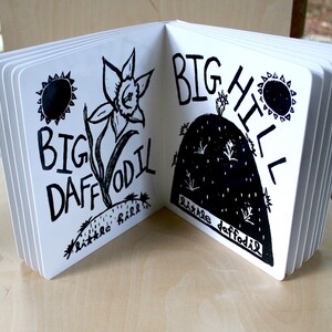 K&ouml;nnte beinhalten: Ein schwarz-wei&szlig; illustriertes Kinderbuch mit dem Text "Big Daffodil" auf der linken Seite und "Big Hill" auf der rechten Seite. Die linke Seite zeigt eine gro&szlig;e Narzisse mit einer Sonne dar&uuml;ber. Die rechte Seite zeigt einen gro&szlig;en H&uuml;gel mit einer kleinen Narzisse oben.