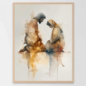 Puede incluir: Impresión artística en acuarela que representa a dos figuras arrodilladas en oración. Las figuras están representadas en tonos suaves de marrón, dorado y azul, con un fondo claro. La obra de arte está enmarcada en un marco de madera natural.