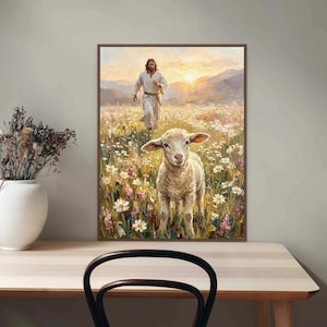 K&ouml;nnte beinhalten: Gerahmtes Kunstwerk, das eine Figur in wei&szlig;en Gew&auml;ndern zeigt, die durch ein Feld mit Wildblumen auf ein Lamm zugeht. Das Gem&auml;lde hat eine warme Farbpalette mit einem Sonnenuntergang im Hintergrund. Das Kunstwerk wird auf einem hellen Holztisch ausgestellt.