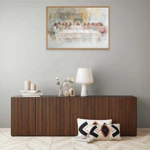 May include: A framed watercolor painting depicting the Last Supper, featuring Jesus and his disciples seated at a table. The painting is set against a light brown background with a soft, ethereal quality.