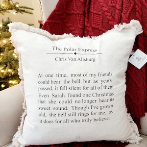 May include: A white throw pillow with frayed edges features a quote from "The Polar Express" by Chris Van Allsburg. The quote reads: "At one time, most of my friends could hear the bell, but as years passed, it fell silent for all of them. Even Sarah found one Christmas that she could no longer hear its sweet sound. Though I've grown old, the bell still rings for me, as it does for all who truly believe."