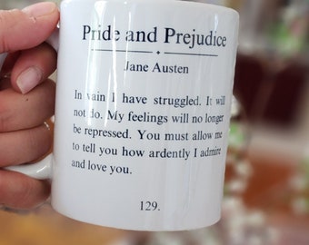 May include: White ceramic mug with a black quote from Jane Austen's "Pride and Prejudice" that reads: "In vain I have struggled. It will not do. My feelings will no longer be repressed. You must allow me to tell you how ardently I admire and love you." The quote is followed by the page number "129."