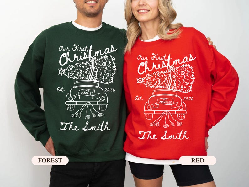 Pu&ograve; includere: Una felpa verde bosco e una felpa rossa, entrambe con una grafica bianca di un'auto che trasporta un albero di Natale con il testo Our First Christmas, Est. 2026, Just Married e The Smith stampato in un carattere corsivo bianco.